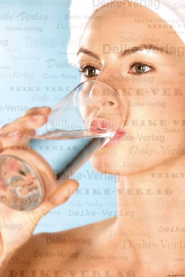 Junge Frau trinkt aus einem Glas Wasser
